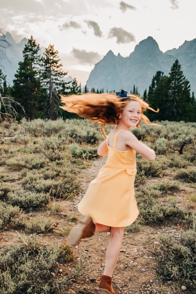 Girl twirling by mountain