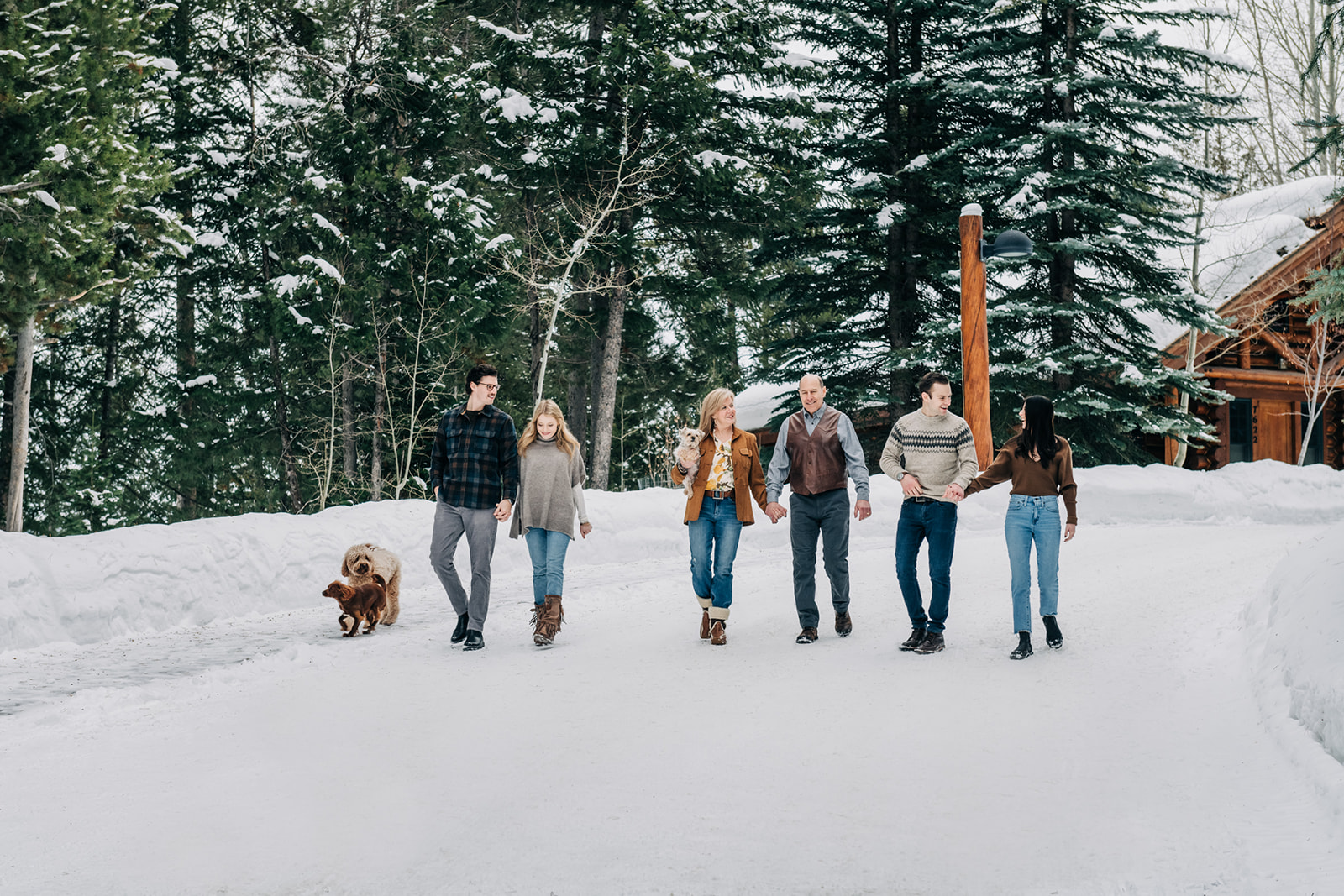 Winter family session in Grand Teton National Park, family walking in snow with dogs