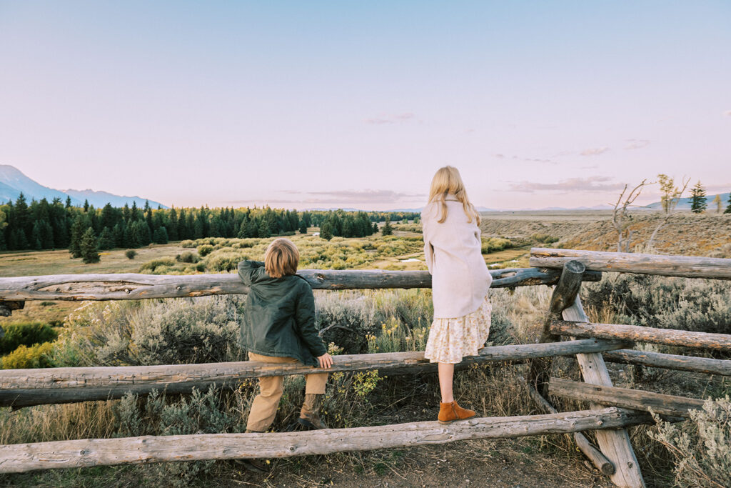 children on fence looking out into Grand Teton National Parks, tips for family photos