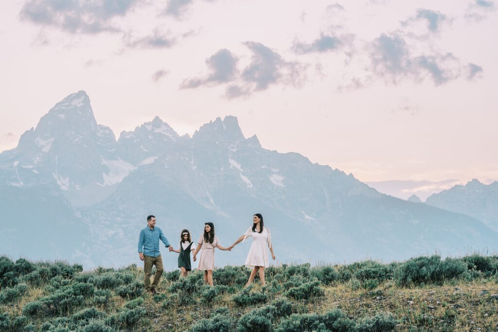 Best time to visit Jackson Hole, family holding hands walking in GTNP in the backdrop