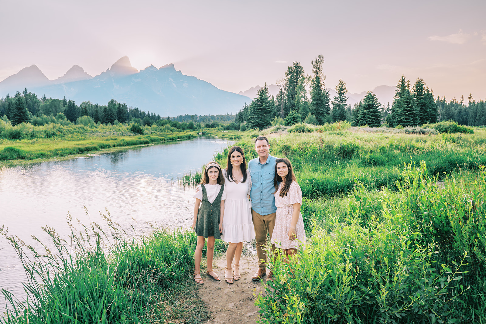 Family session at sunset at Schwabacher Landing, family smiling in front of Snake River