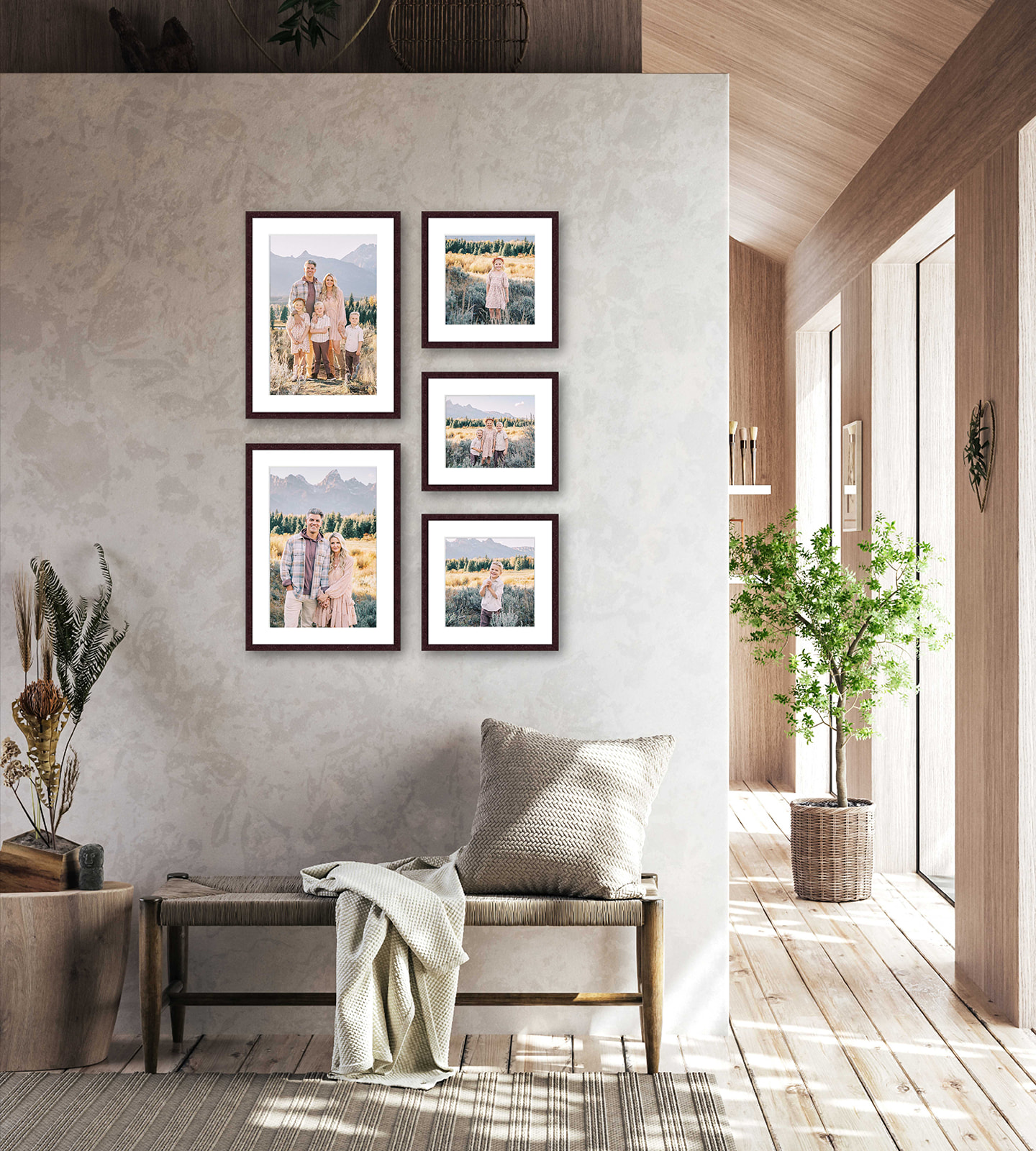 Five fine art family photos hang on a grey wall in an entryway